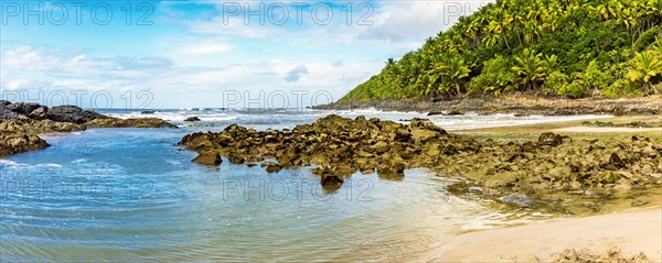 Sea between vegetation and rocks at Prainha beach in Serra Grande on the south coast of Bahia