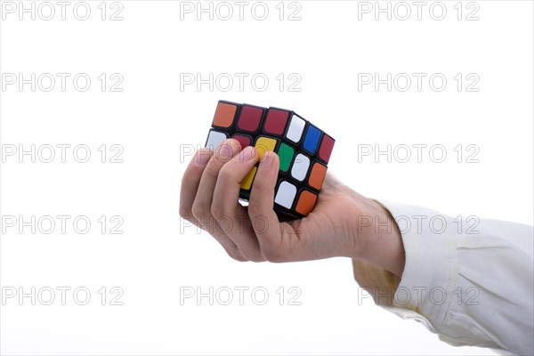 Child holding a Rubik's cube in hand on a white background