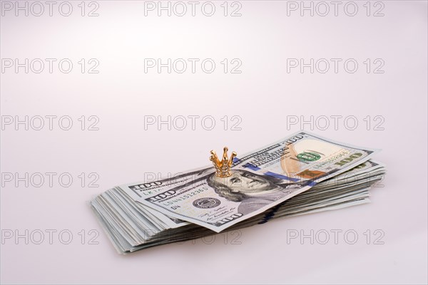 Crown placed on American 100 dollar banknotes on white background