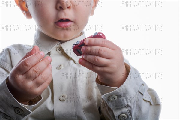 Baby hand holding a red car on a white background