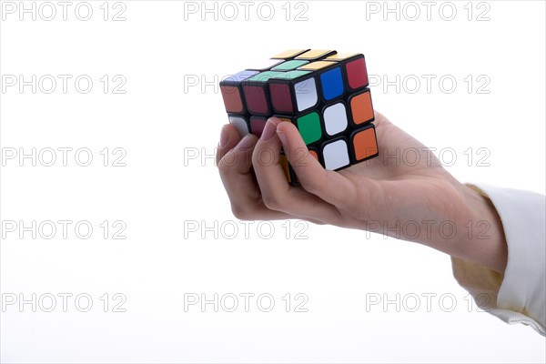 Child holding a Rubik's cube in hand on a white background