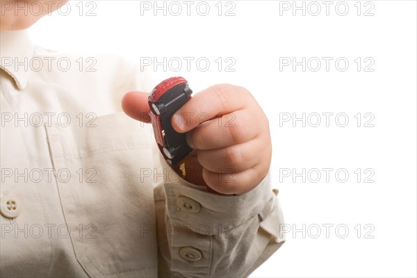 Baby hand holding a red car on a white background