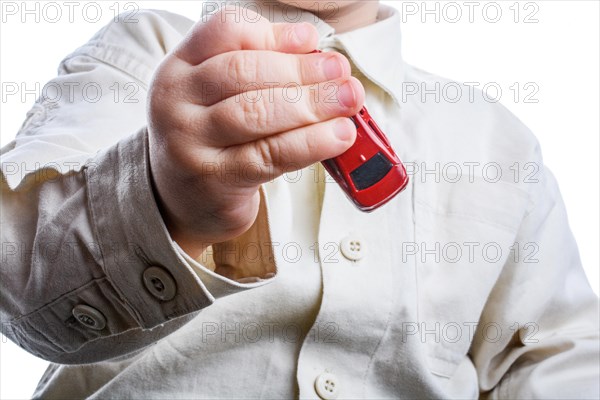 Baby hand holding a red car on a white background