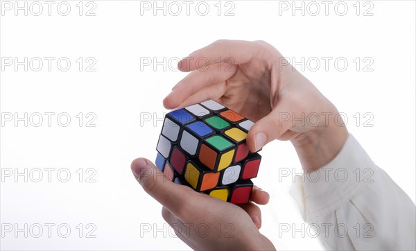 Child holding a Rubik's cube in hand on a white background