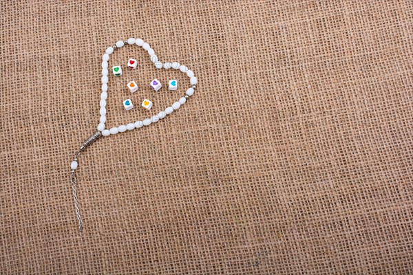 Heart shaped cubes in hand by inside a praying beads