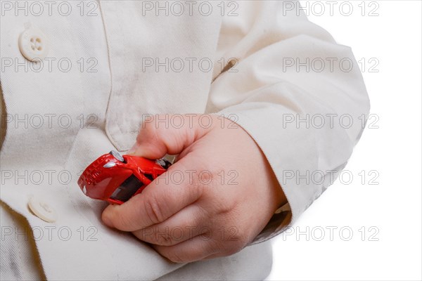 Baby hand holding a red car on a white background