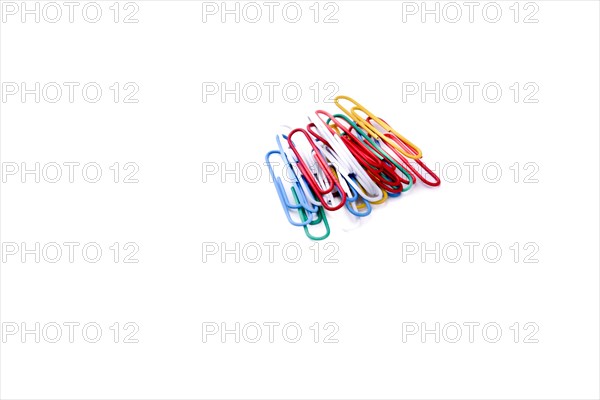 Colurful paperclips piled on a white background