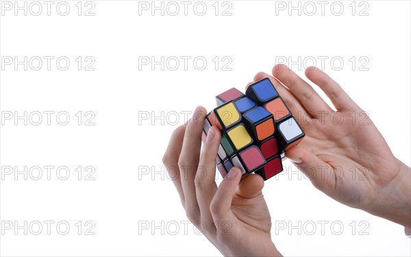 Child holding a Rubik's cube in hand on a white background