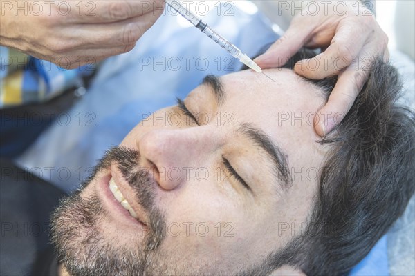 Latin man getting filler injections in aesthetic medical clinic