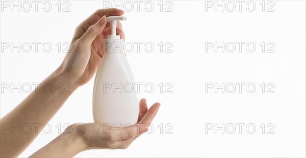Hand holding liquid soap bottle with copy space