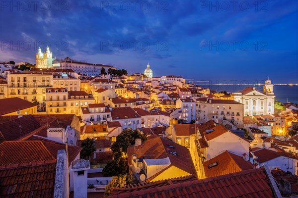 View of Lisbon famous view from Miradouro de Santa Luzia tourist viewpoint over Alfama old city district at night. Lisbon