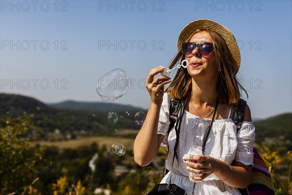 Woman white dress making soap bubbles