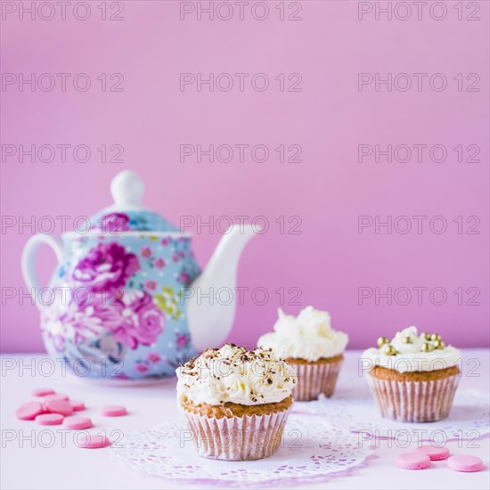 Cupcakes candies teapot white surface