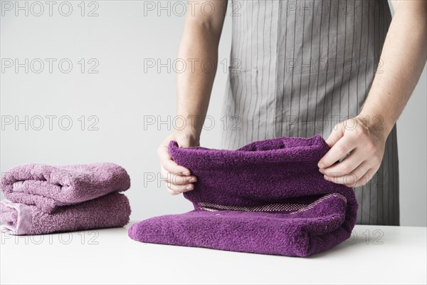 Front view person folding towels