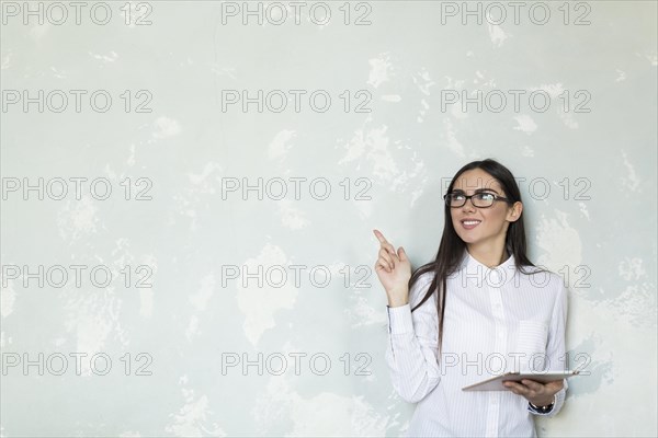 Young girl with tablet pointing up