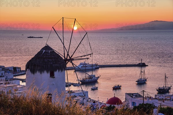 Famous traditional Greek windmill overlook port and harbor of Mykonos