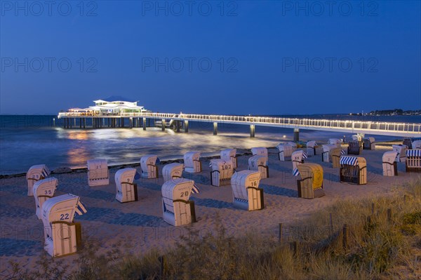 Seeschloesschenbruecke with restaurant Wolkenlos and beach chairs at Timmendorfer Strand at night