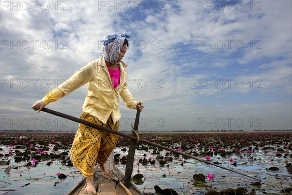 Woman in boat at sea with water lilies