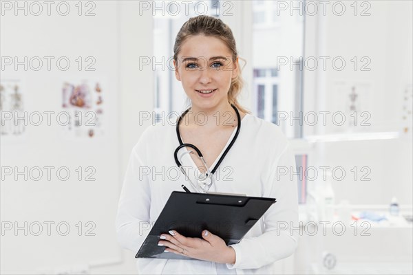 Medium shot doctor holding clipboard