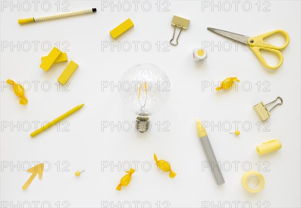 Fluorescent bulb surrounded by various stationeries candies