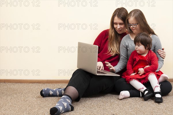 Front view woman children with down syndrome looking laptop