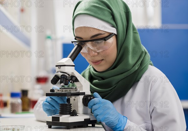 Female scientist with hijab microscope laboratory