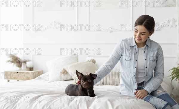 Medium shot girl petting dog bed