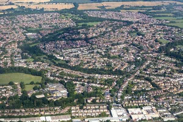 Oblique aerial view through plane window of housing estates in Bishop's Stortford town