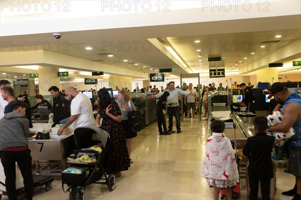 People passing through security check inside Cancun airport