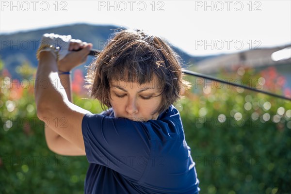 Front View on a Female Golfer Making a Golf Swing in a Sunny Day in Switzerland