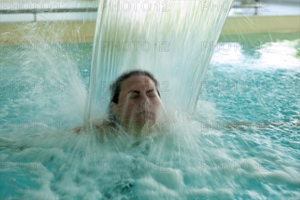 Woman Face Relax in a Hydromassage Pool with Falling Water in Long Exposure in Switzerland