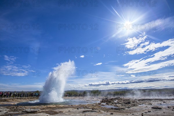 Water explosion in the Geysir Strokkur with the sun in the background of the golden circle of the south of Iceland