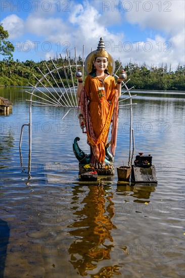 Hindu goddess statue figure sculpture of goddess deity Parvati woman consort Shakti of Lord Shiva Hindu mother goddess mother of Ganesha stands in lake sacred Hindu lake Ganga Talao at religious site largest Hindu sanctuary sanctuary for religion Hinduism outside of India for devout Hindu Hindus
