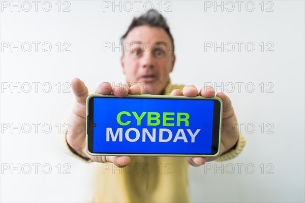 Crazy man holding mobile phone with Cyber Monday advertisement on the screen