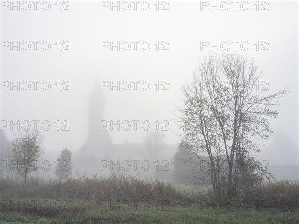 Church tower in the morning mist