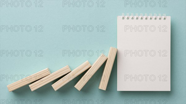 Arrangement financial crisis with wooden pieces blank notepad