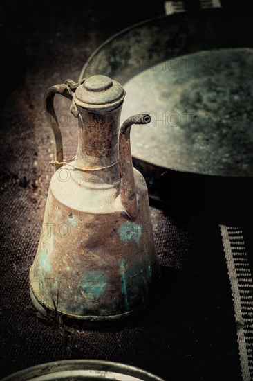 Ancient metal jug in oriental style in antique market