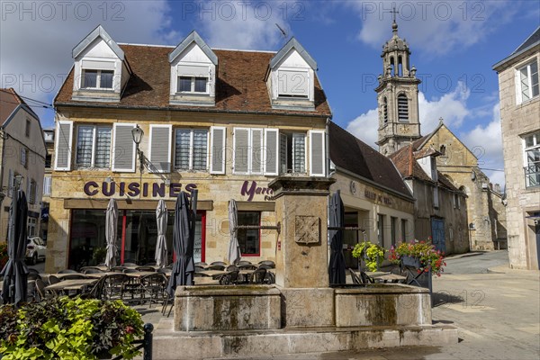 The fountain in Rue Diderot and the church tower in the background Catholic church Eglise Saint Martin