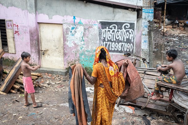 Woman with washed clothes and two boys