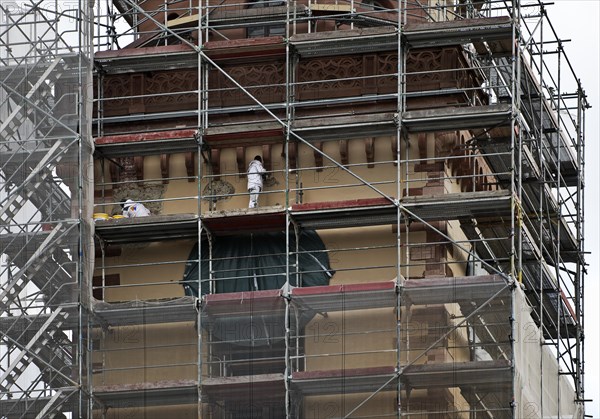 Scaffolded tower of St Catherine's Protestant Church with construction workers