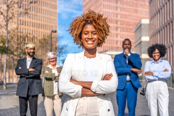Frontal photo of a smiling african businesswoman standing next to colleagues