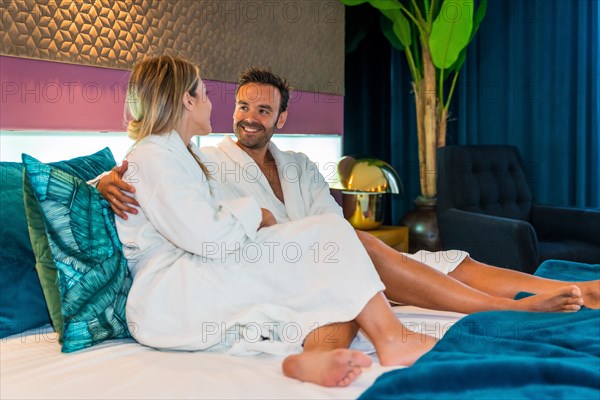 Romantic moment of a couple dressing gown in a hotel room