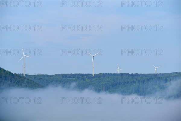 Wind turbines on a hill on a foggy morning