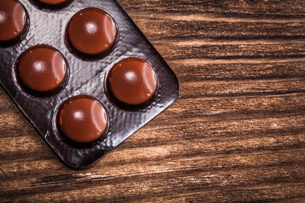 Pills in a pack on an old wooden board