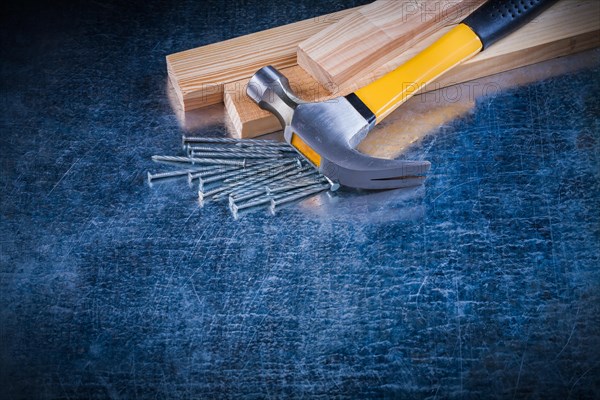 Construction nails Claw hammer and wooden tile on scratched metal surface Maintenance concept