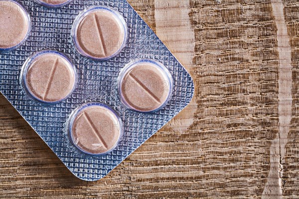 Pills in blister pack on vintage wooden board medical concept