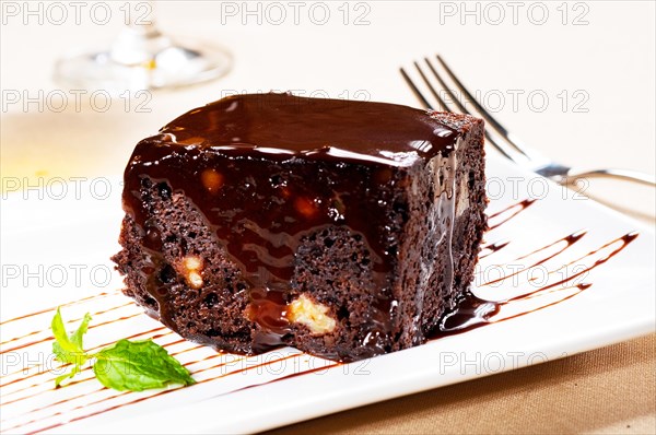 Fresh baked delicious chocolate and walnuts cake with mint leaf beside