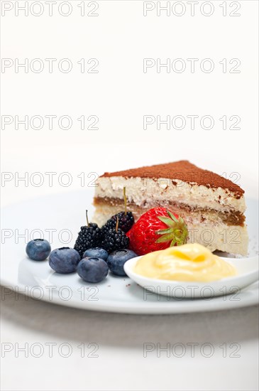 Classic Italian tiramisu dessert with berries and custartd pastry cream on side