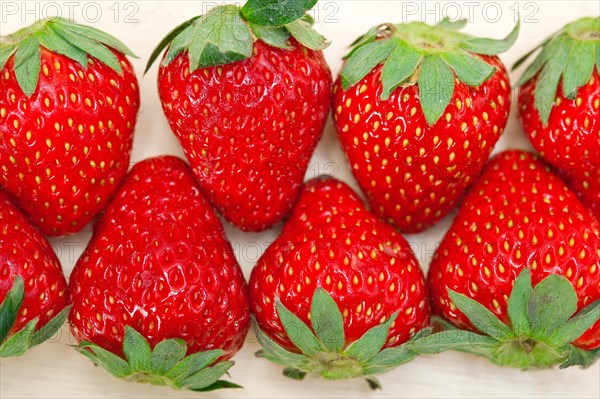 Fresh organic strawberry over white rustic wood table