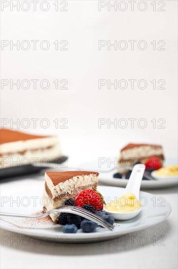 Classic Italian tiramisu dessert with berries and custartd pastry cream on side